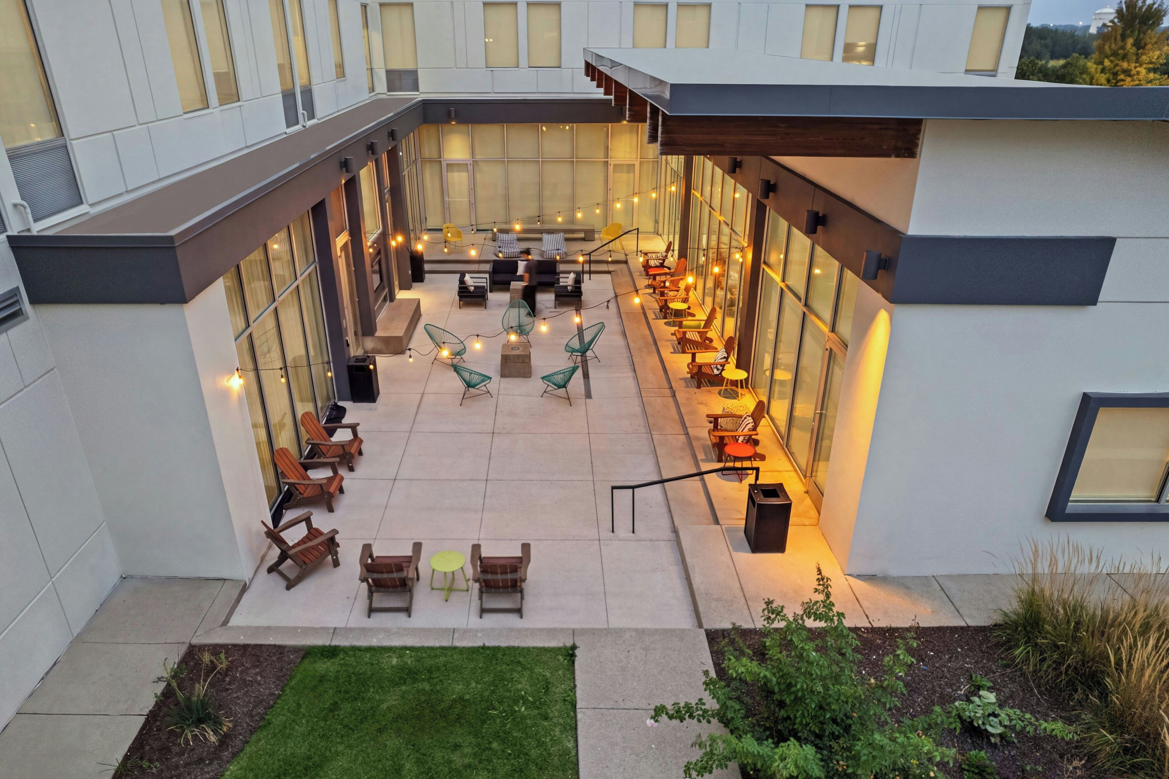 A courtyard with outdoor seating, a central table, and a small lawn area.