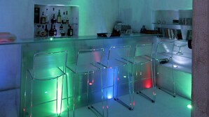 Eine Eisbar mit klaren Glas-Bistrostühlen und Flaschenregalen.