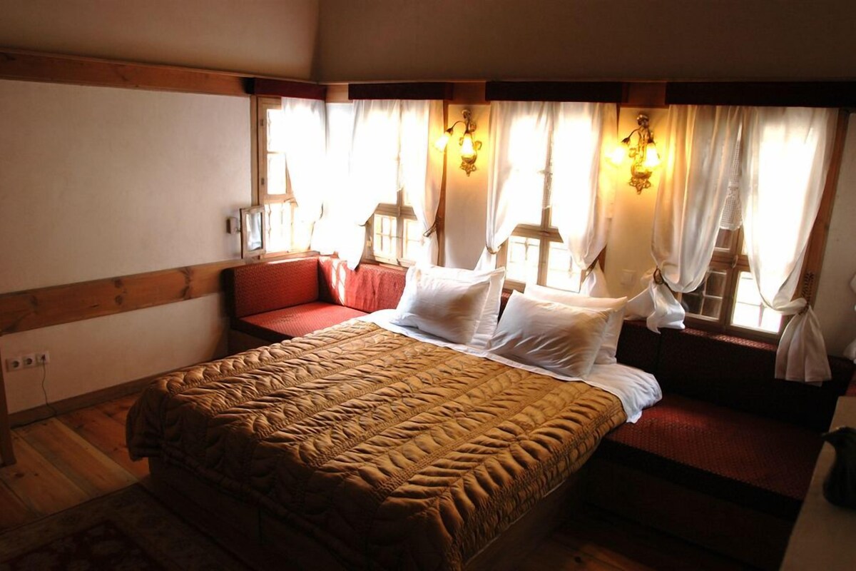 Une chambre à coucher avec un lit, un canapé rouge et des rideaux.