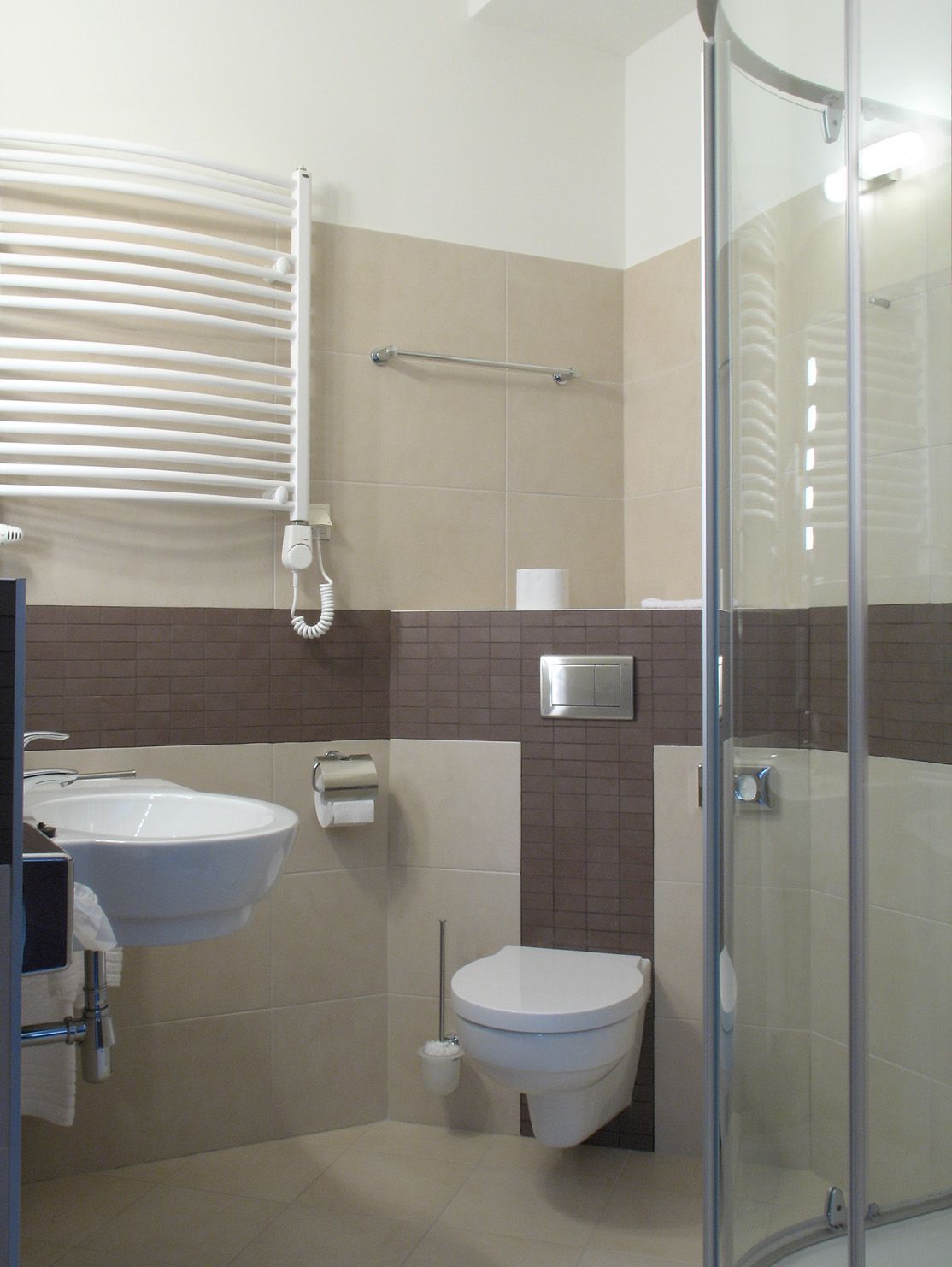 A bathroom with a sink, toilet, and glass shower enclosure.