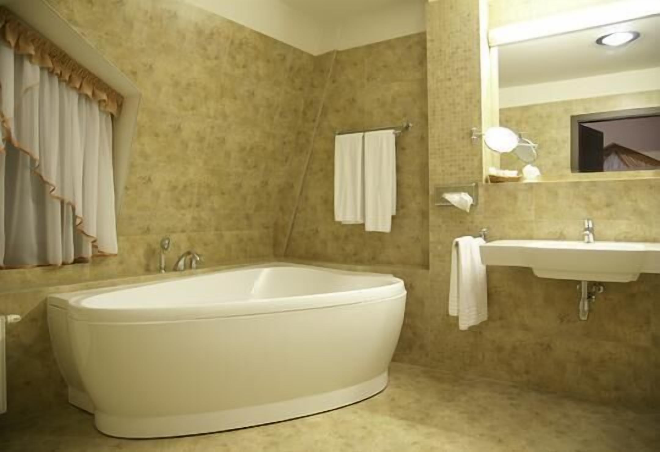 A bathroom with a freestanding bathtub, a sink, a mirror, and a towel rack.