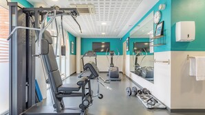 A gym with exercise equipment, a treadmill, weights, and a mirror. - Appart'City  Classic Toulouse Colomiers (Colomiers)
