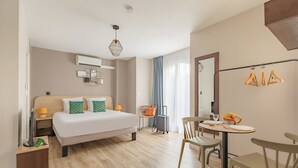 A hotel room with a bed, bedside tables, a desk with chairs, a mirror, and a window with curtains. - Appart'City  Classic Toulouse Colomiers (Colomiers)