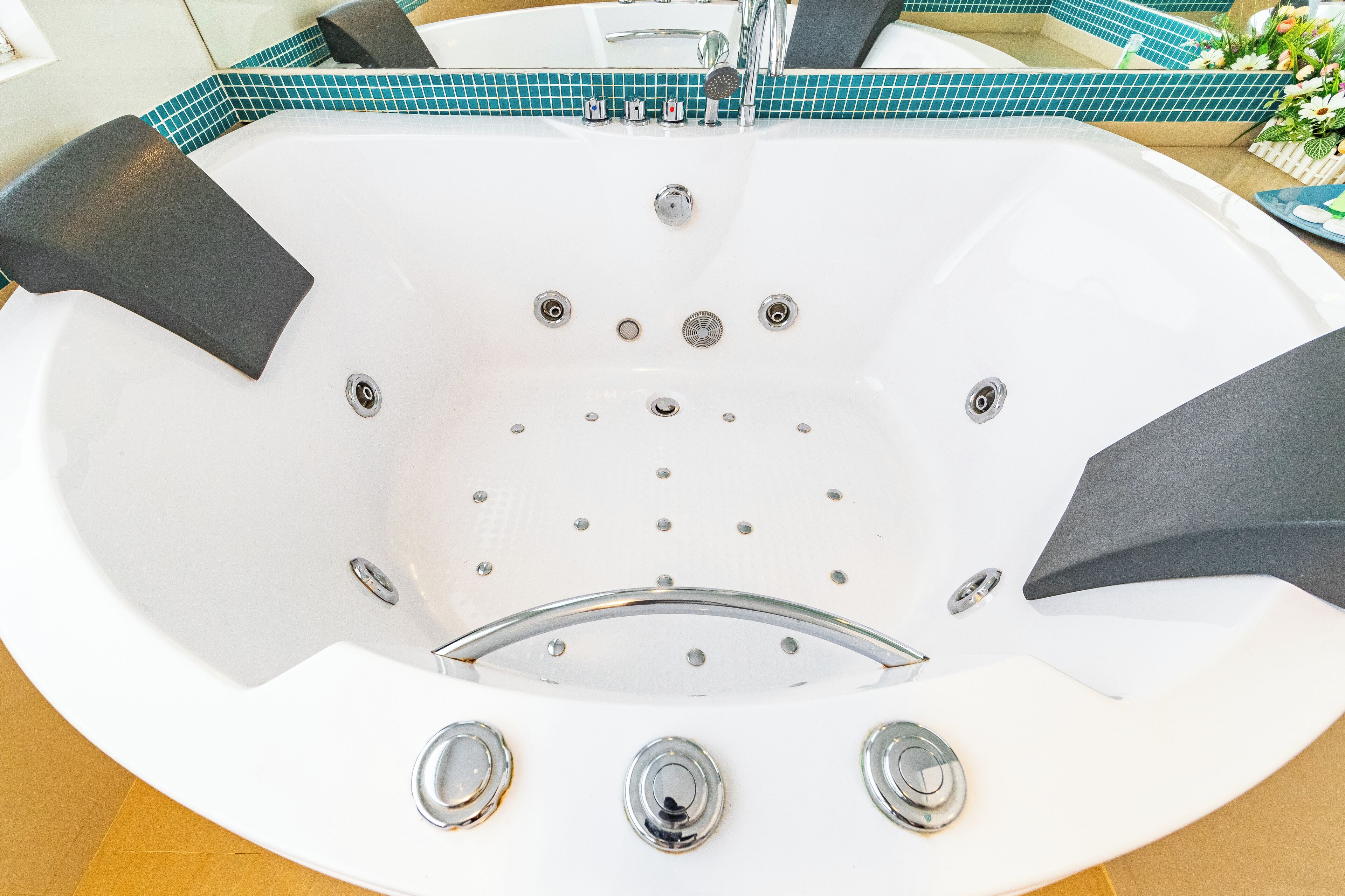 A white bathtub with a chrome faucet, multiple jets, and a showerhead.