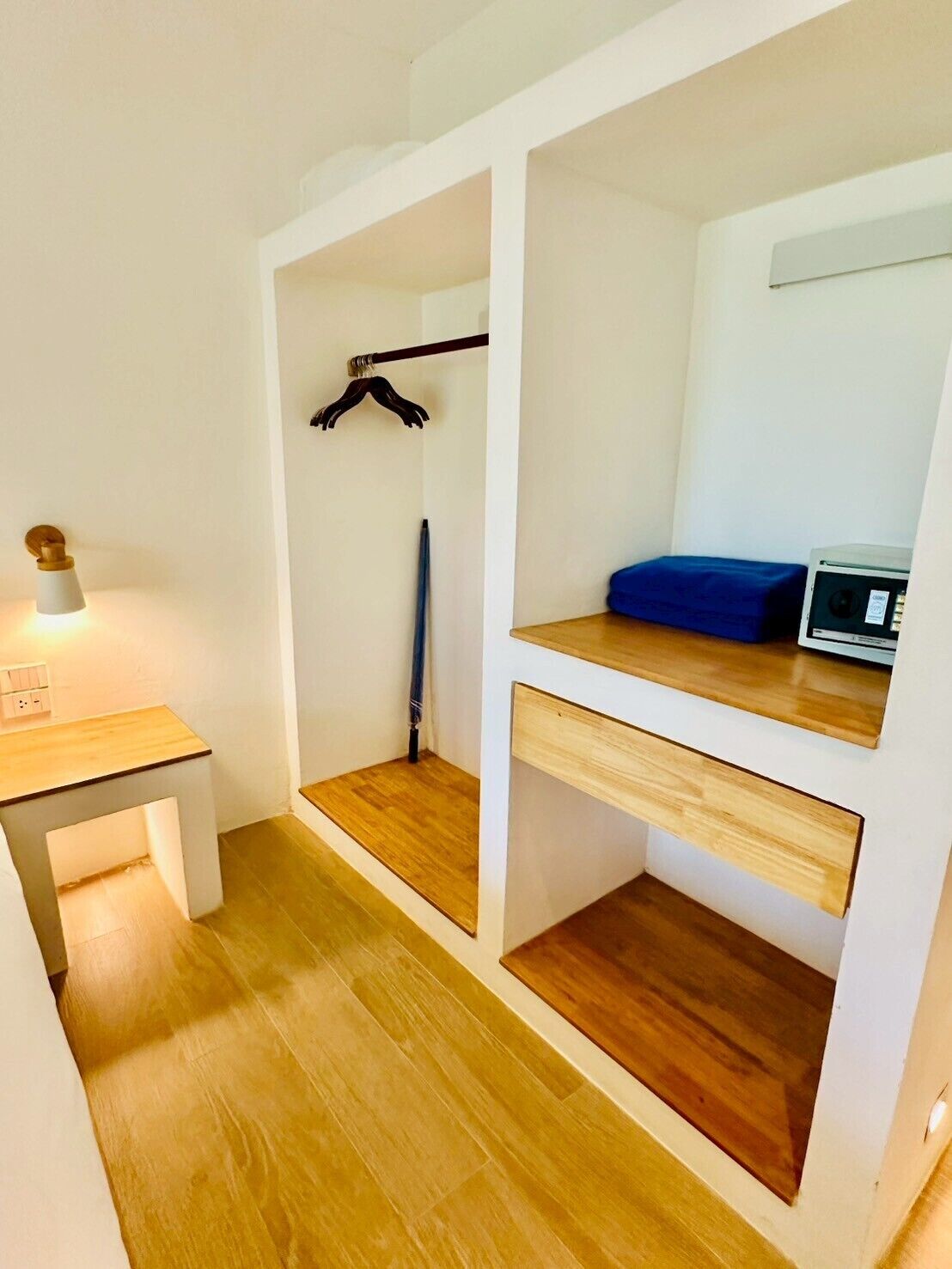 A compact room with a bed, a small desk, and a heater.