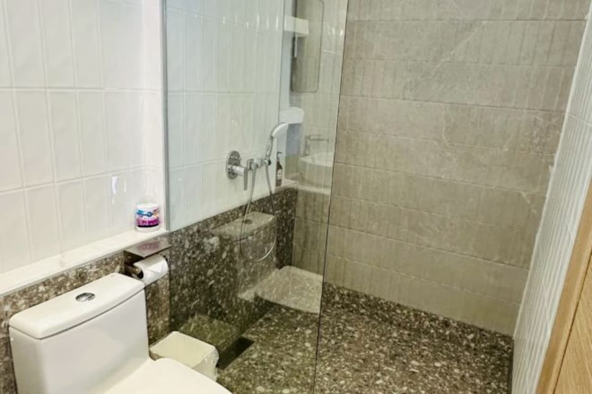 Un baño con inodoro, lavamanos y zona de ducha.