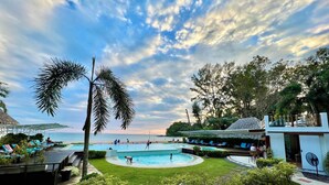 A resort with a swimming pool, lounge areas, and a view of the sea. - Twin Bay Resort (Ko Lanta)