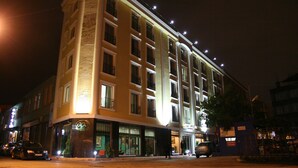 Un hotel de varios pisos con ventanas iluminadas y un cartel que indica que es un hotel.