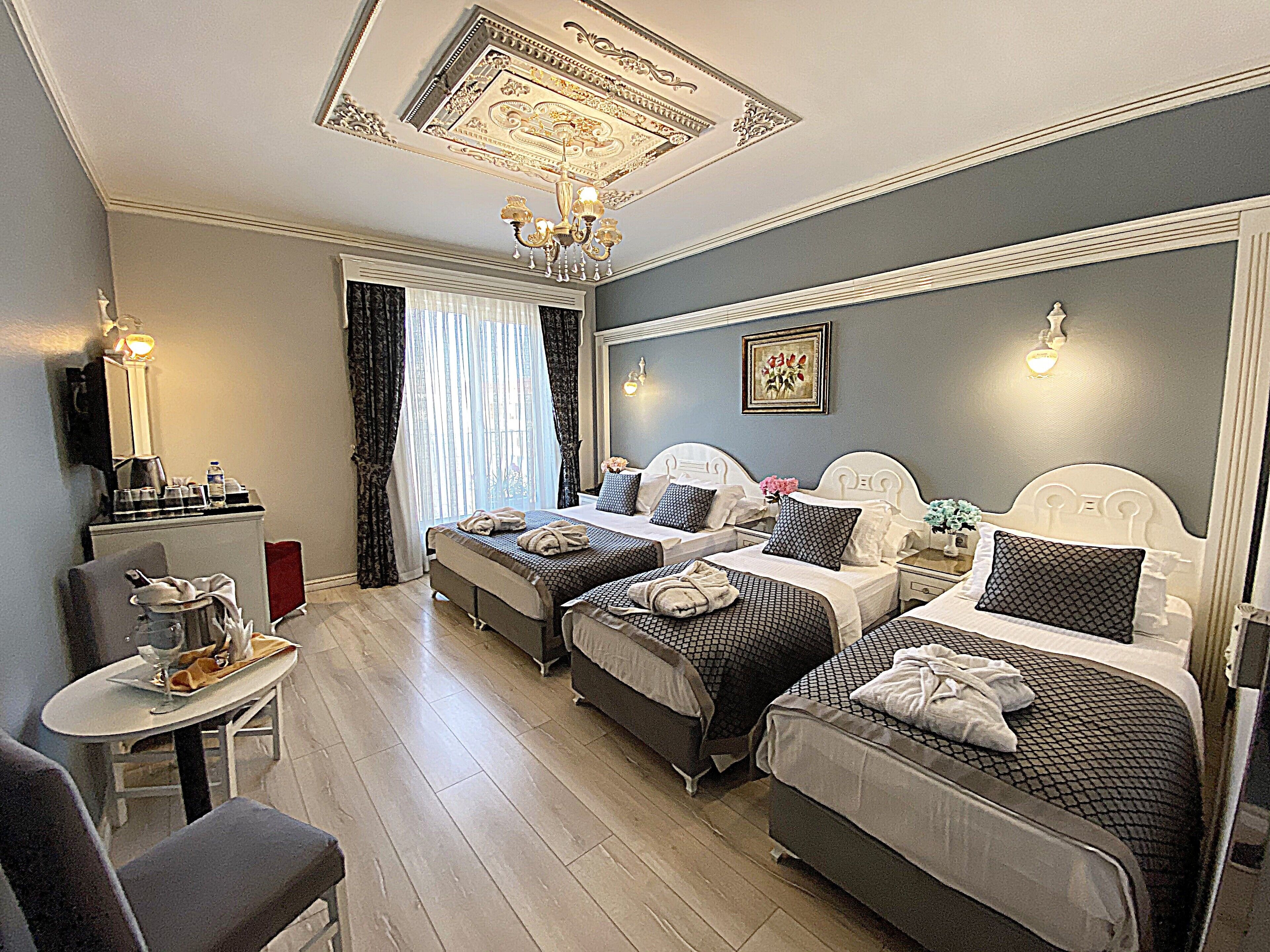 A hotel room with two beds, a desk, and a chair.