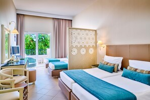 Habitación de hotel con una cama grande, un escritorio con silla, un balcón con cortinas y un panel decorativo en la pared.