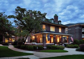 A two-story brick house with a porch, a flag, and a well-maintained lawn. - Graduate by Hilton Columbia SC (Columbia)