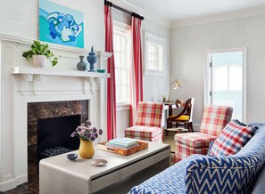 A living room with a fireplace, a sofa, a coffee table, and a chair.