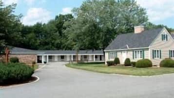 A two-story building with a central entrance, surrounded by a paved driveway and landscaped areas.