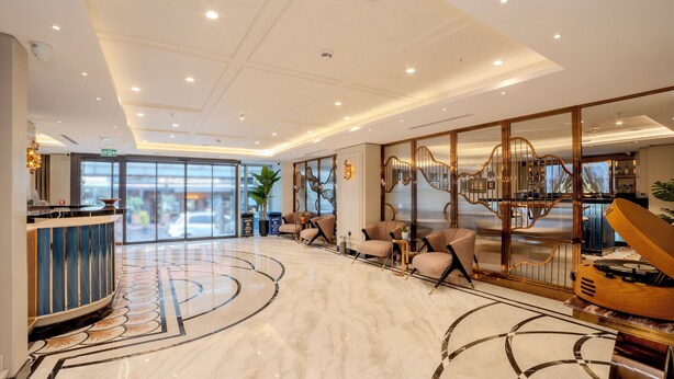 A spacious lobby with a marble floor, seating area, reception desk, and a staircase with a decorative railing. - Grand Hilarium Hotel (Istanbul)