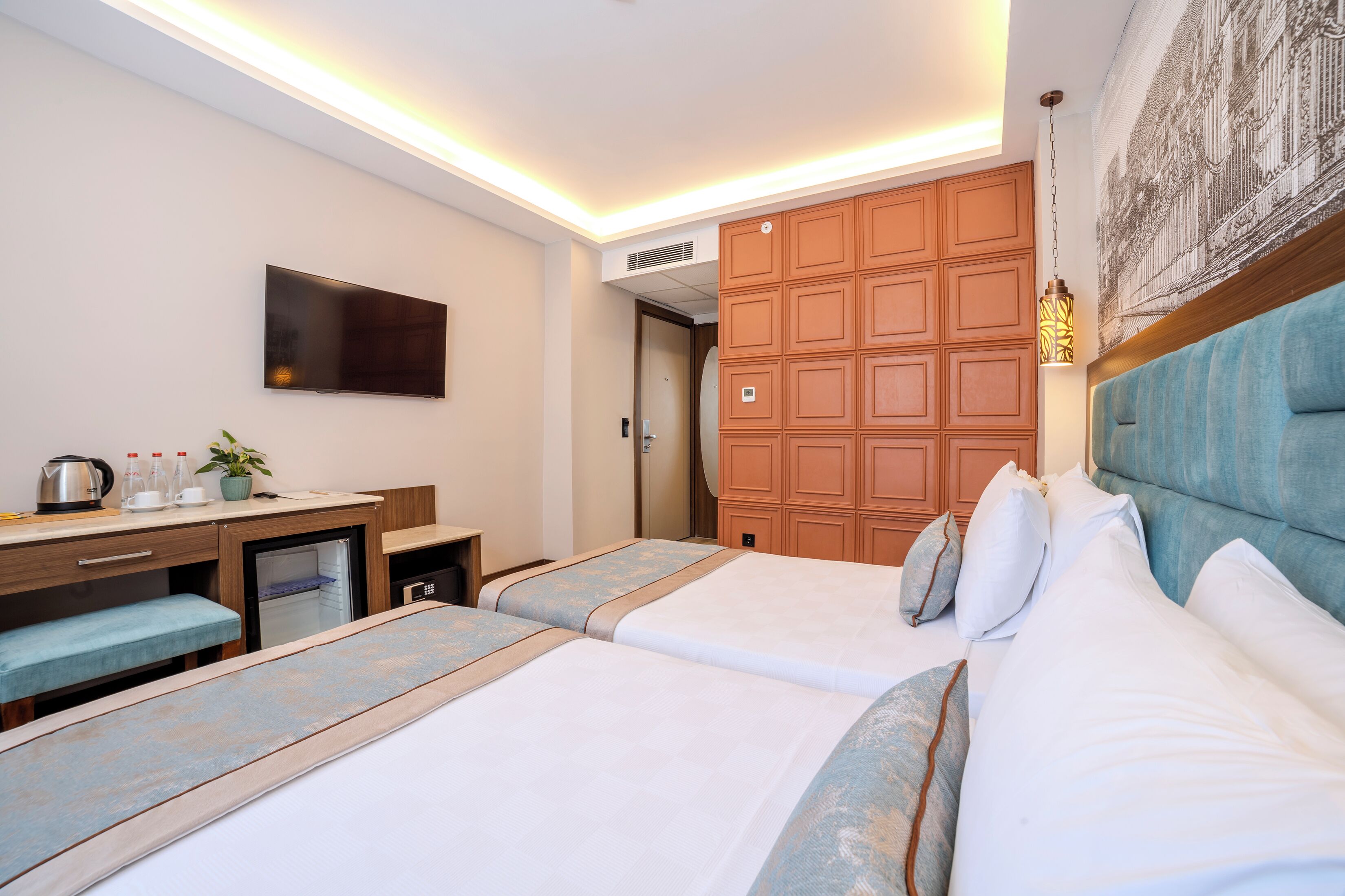 A hotel room with two beds, a desk, a television, and a wardrobe.