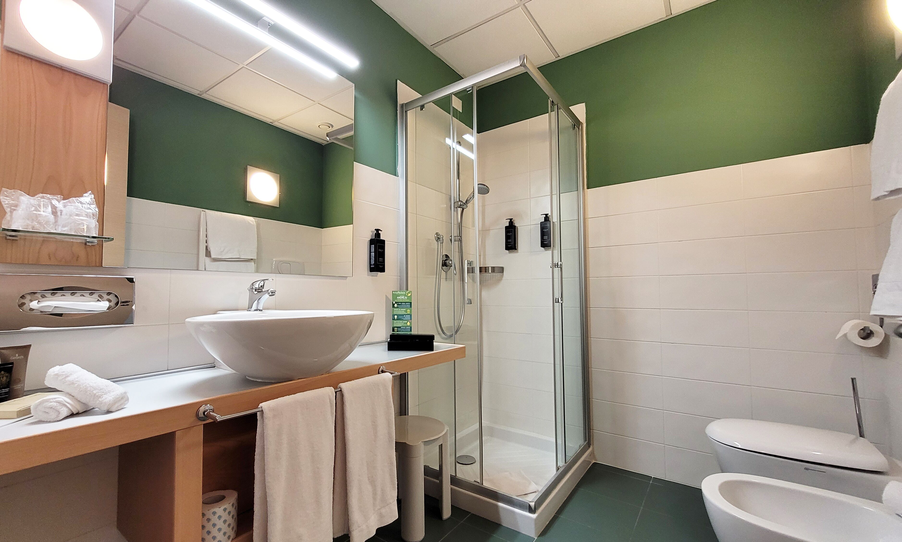 A bathroom with a large sink, a glass-enclosed shower, and a toilet.