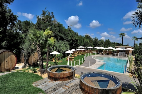 Una piscina al aire libre de temporada, sombrillas