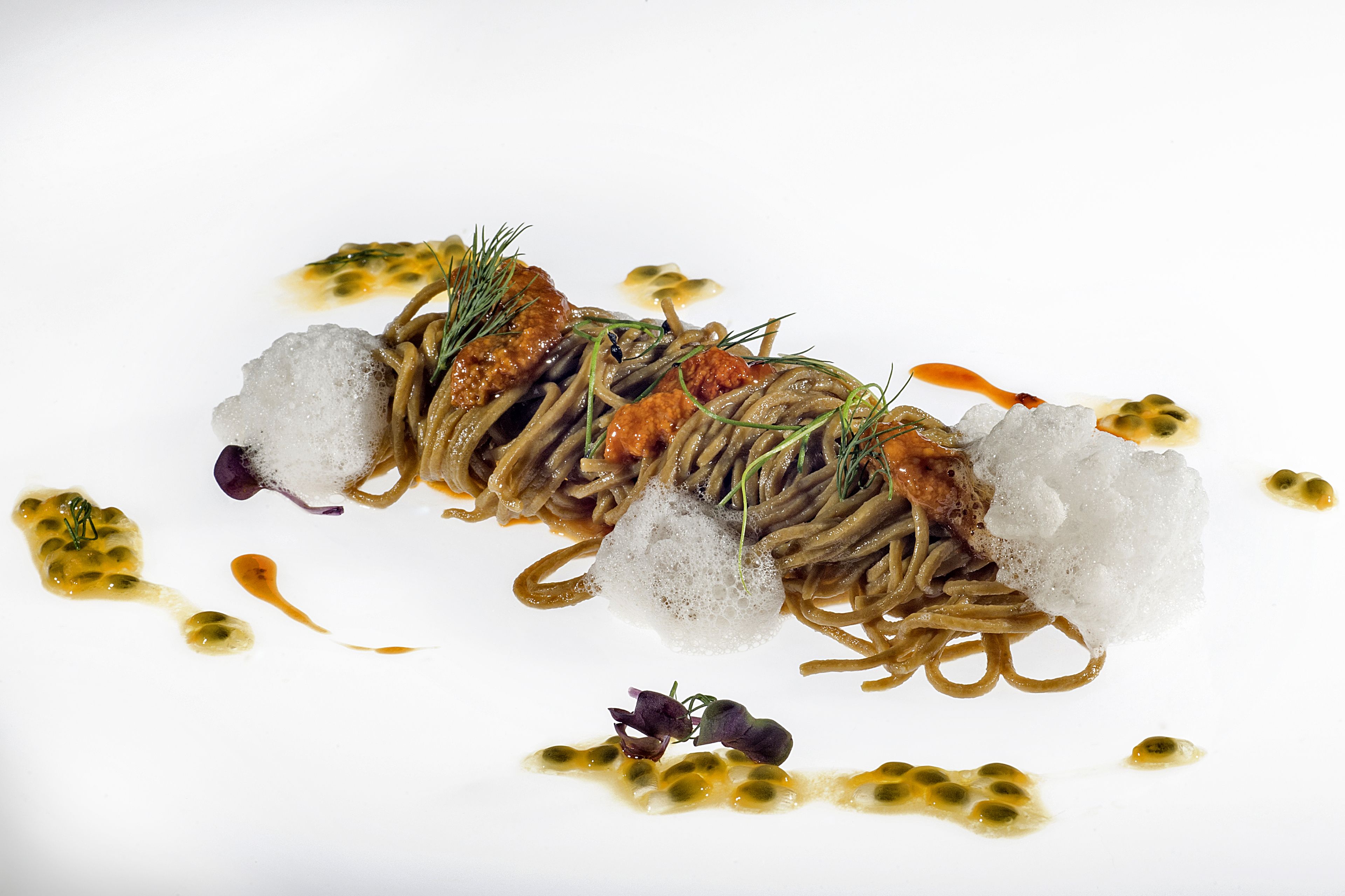 Un piatto con noodles, ghiaccio e guarnizioni.