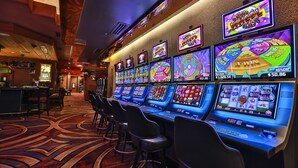 Een casino verdeler met meerdere gokkasten en een bar.