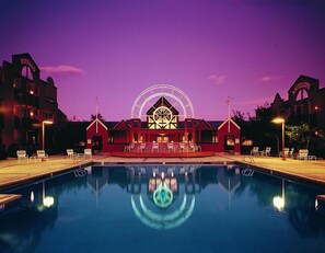 Un hotel con piscina, noria y un amplio ventanal circular con diseño de estrella.