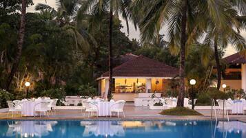 Una piscina al aire libre, sombrillas, sillones reclinables de piscina