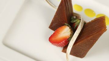 Dessert met aardbei en chocolade op een wit bord.
