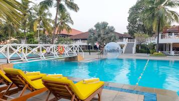Relax by the pool surrounded by palm trees and lounge chairs.