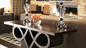 A modern living room with a stone accent wall, a fireplace, and a dining area with a unique table design.