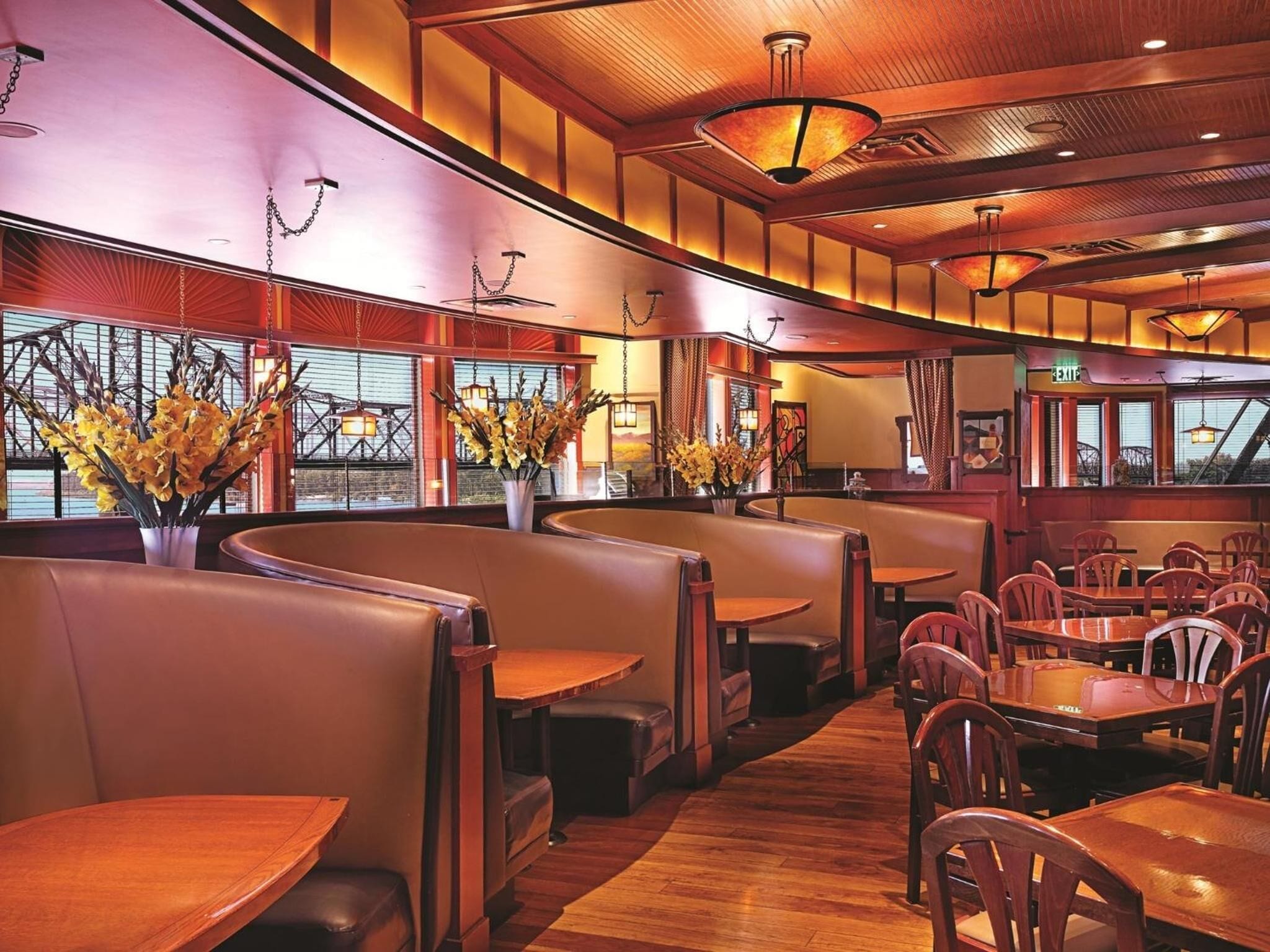 Un restaurante con asientos tipo cabina, mesas de madera y una decoración interior acogedora.