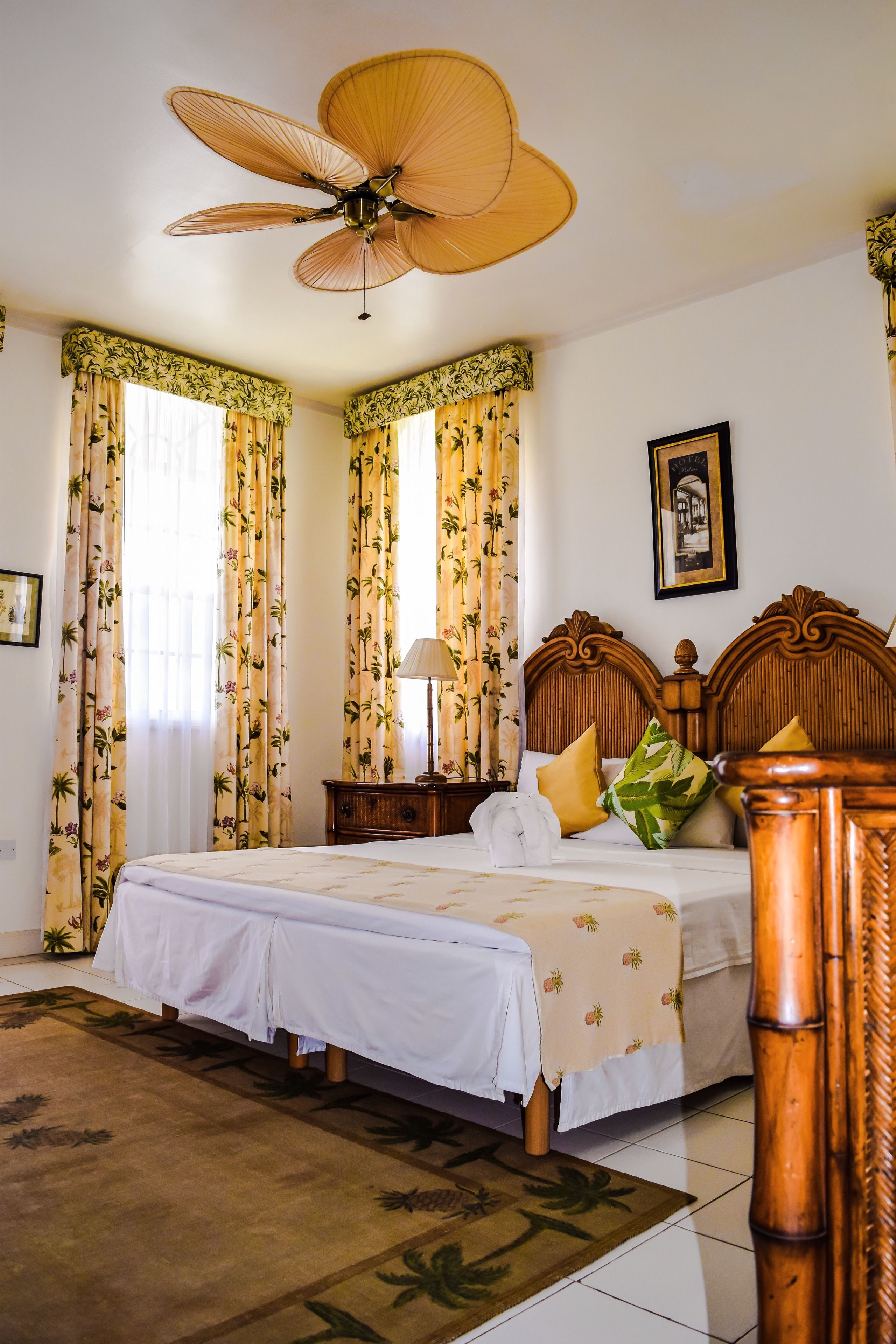 Une chambre à coucher avec un lit, une table de chevet, une lampe et un ventilateur de plafond.