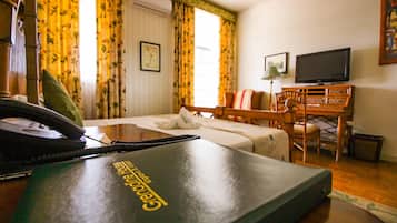 Een hotelkamer met een bed, een bureau, een stoel, een televisie en een telefoon.