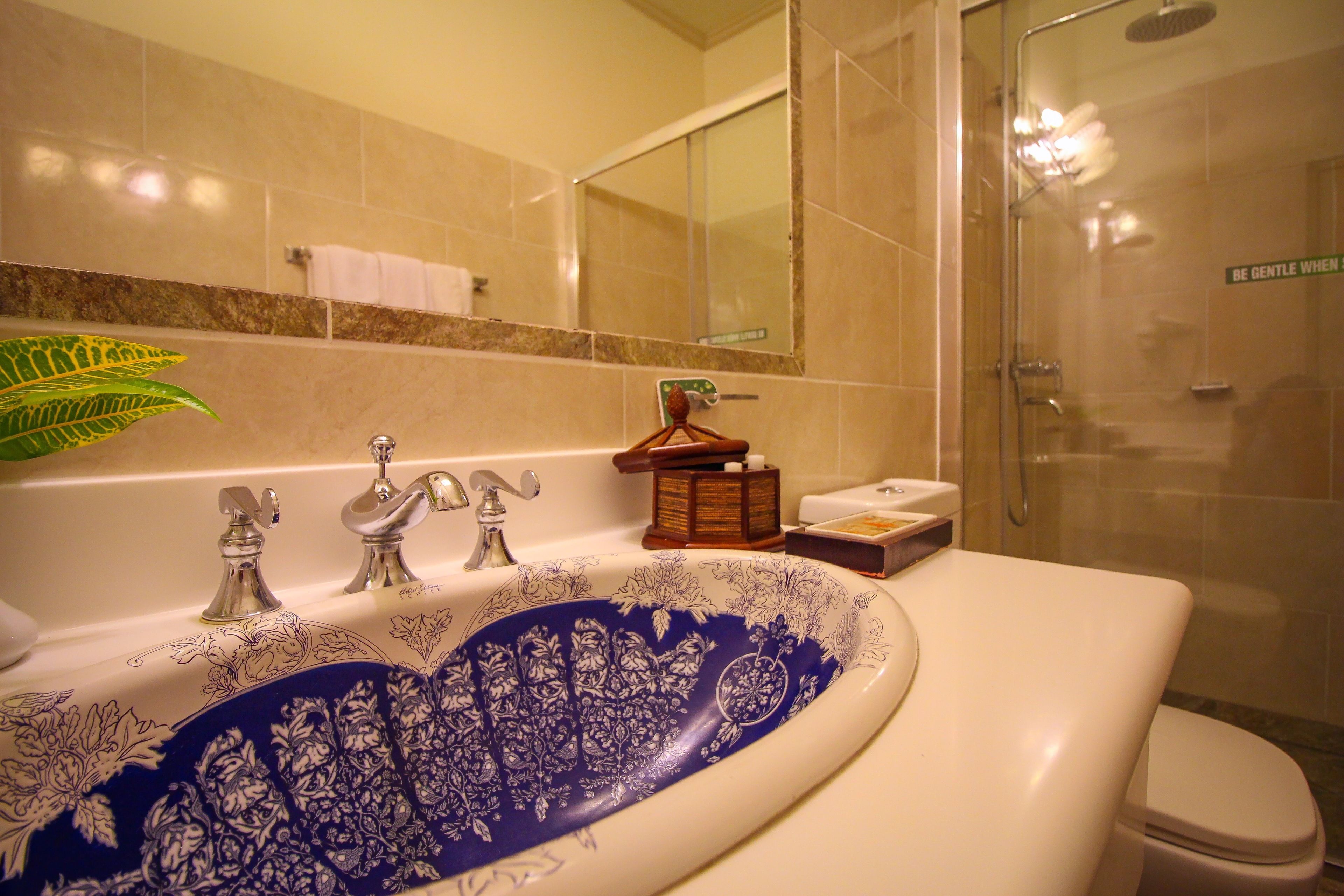 A bathroom with a large bathtub, a toilet, and a shower area.