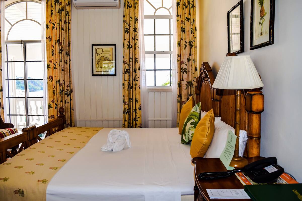 Ein Hotelzimmer mit einem Bett, einem Schreibtisch, einer Lampe und einem Telefon.