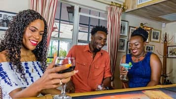 Trois personnes sont assises au bar, avec vue sur l’extérieur.