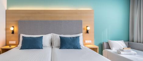 A hotel room with a double bed, two bedside tables, a nightstand, a desk, and a chair.