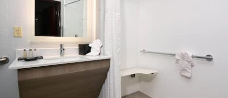 Un baño moderno con ducha, lavabo, espejo y toallero.
