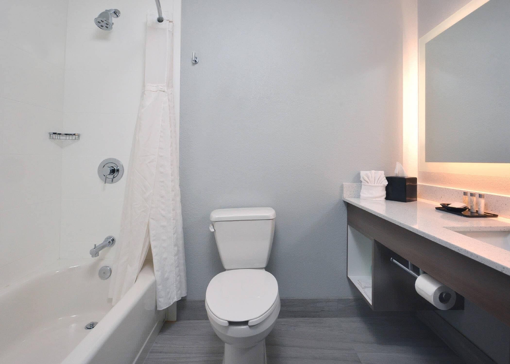 Ein modernes Badezimmer mit Badewanne, Toilette und Waschbecken.