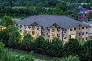 A multi-story hotel with a stone facade, multiple balconies, and a view of surrounding greenery. - Brookstone Lodge near Biltmore Village, an Ascend Collection Hotel (Asheville)