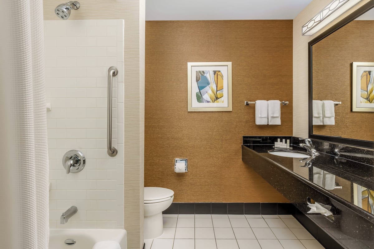 Un baño moderno con ducha, inodoro y lavamanos.