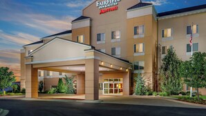 Een Fairfield Inn & Suites Marriott hotel met een overdekte ingang en een aangelegde voortuin.