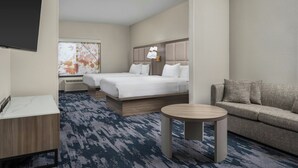 A hotel room with a bed, a sofa, a small table, and a TV. - Fairfield Inn & Suites by Marriott Dallas Mansfield (Mansfield)