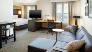 A hotel room with a bed, a desk with a computer, a sofa, and a TV. - Residence Inn by Marriott New Orleans Covington/North Shore (Covington)