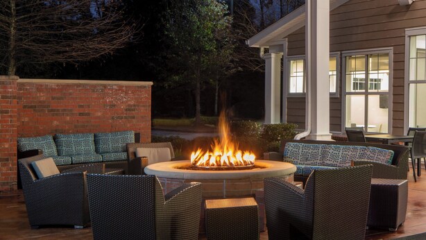 An outdoor seating area with wicker furniture and a central fire pit. - Residence Inn by Marriott New Orleans Covington/North Shore (Covington)