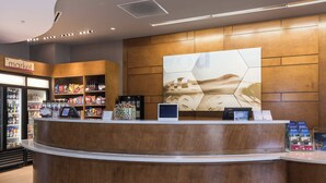 A reception area with a wooden counter, a refrigerator stocked with snacks, and a large informational poster on the wall.