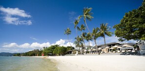 On the beach, white sand, sun loungers, beach umbrellas