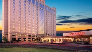 Een meerhoog hotel met een opvallend 'AMERISTAR' bord, met een modern architectonisch ontwerp, grote ramen en een plat dak.