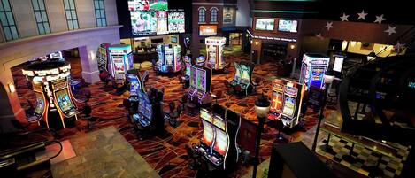 A casino with multiple slot machines and a bar area.