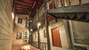 A multi-level wooden building with balconies, air conditioning units, and a wooden door. - Cappadocia Palace Hotel (Ürgüp)
