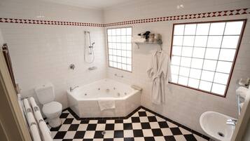 Un baño con piso a cuadros, una bañera, un inodoro, una ducha y un lavamanos.