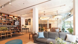 A modern library with bookshelves, a sofa, and a dining area. - Zinema7 (San Sebastián)